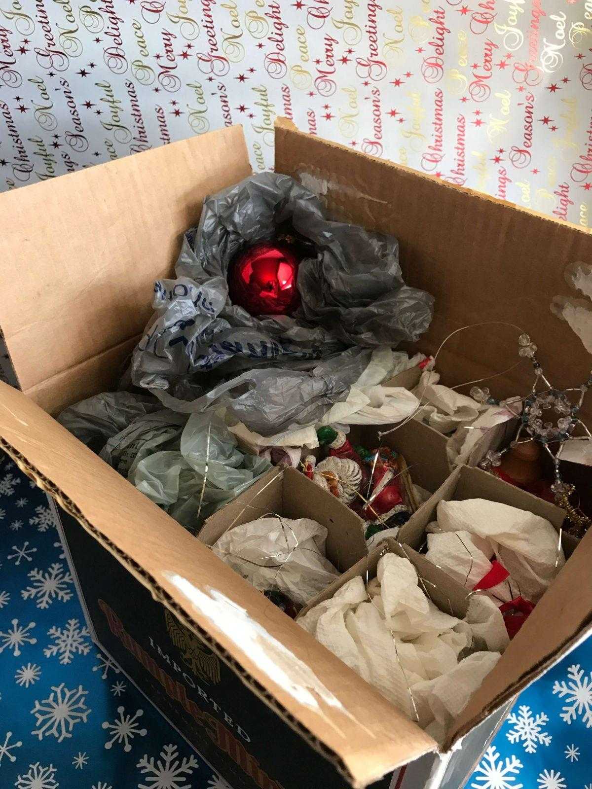 Weihnachtsdekoration einpacken in einen Flaschenkarton